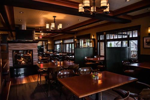 a restaurant with tables and chairs and a fireplace at Salt Spring Inn in Ganges