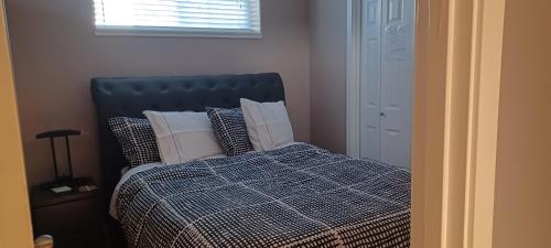 a bedroom with a bed with pillows and a window at 680 SQ FT Private Space With Ensuite Bathroom in Calgary