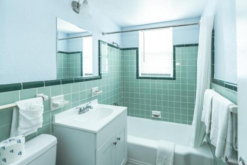 een badkamer met een wastafel, een toilet en een bad bij Echo Sails Motel in Clearwater Beach