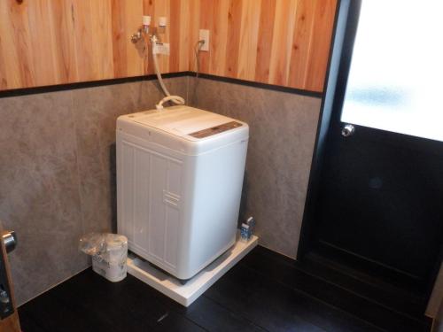a small refrigerator in a bathroom next to a door at Kabuto Villas ー古民家ステイー 