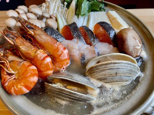 a plate of food with shrimp and other seafood at Hotel EL 8（宇都宮駅東口） in Utsunomiya