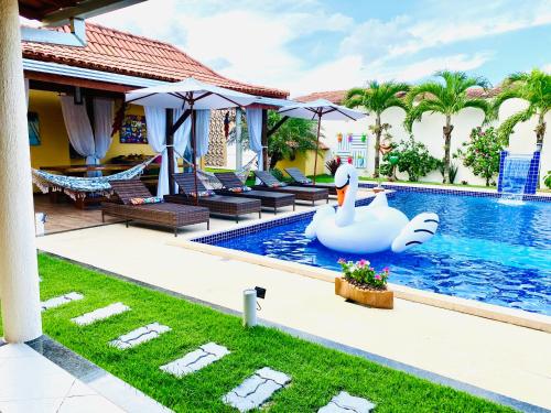 einen Pool mit einem Schwan in der Mitte eines Hauses in der Unterkunft Villa Paradise in Brazil - Praia de Guaratiba Prado-BA in Prado