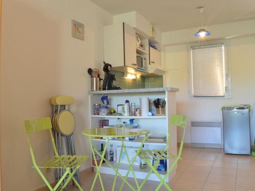 une cuisine avec une table et des chaises dans une pièce dans l'établissement Maison triplex 2 chambres 6 pers, proche plage, parking, terrasse, animaux admis - FR-1-225C-29, à Banyuls-sur-Mer