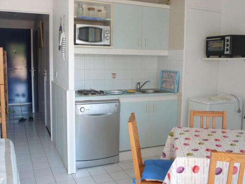 La cuisine est équipée d'une cuisinière, d'un évier et d'un lave-vaisselle. dans l'établissement Appartement 2 étoiles avec piscine, balcon, 2 chambres, proche plage - Le Lavandou - FR-1-308-92, au Lavandou