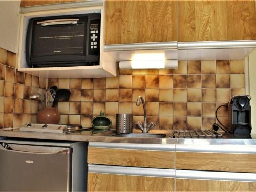 une cuisine avec un évier et un micro-ondes dans l'établissement Studio calme pied de pistes, 4 couchages, Risoul 1850 - FR-1-330-481, à Risoul
