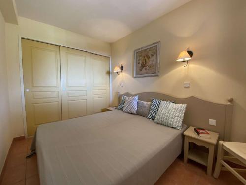 une chambre avec un grand lit avec deux oreillers dans l'établissement Les Issambres : Appt avec Piscine, Tennis, et Parking au Rez de Jardin - FR-1-226-380, aux Issambres