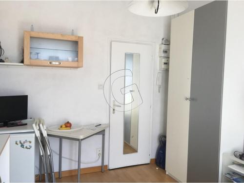 une petite cuisine avec une table et un réfrigérateur dans l'établissement Studio idéal au centre-ville de La Tranche-sur-Mer, à 80m de la plage, avec balcon et aperçu mer - FR-1-357-240, à La Tranche-sur-Mer