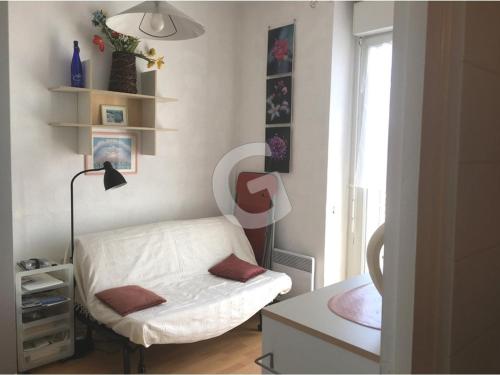 a small bedroom with a white bed and a window at Studio idéal au centre-ville de La Tranche-sur-Mer, à 80m de la plage, avec balcon et aperçu mer - FR-1-357-240 in La Tranche-sur-Mer