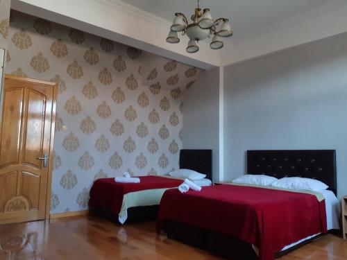バトゥミにあるDzveli Batumiのベッドルーム1室(赤いシーツを使用したベッド2台付)