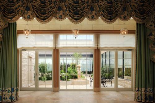 a room with large windows and green curtains at Hotel Monterey Grasmere Osaka in Osaka