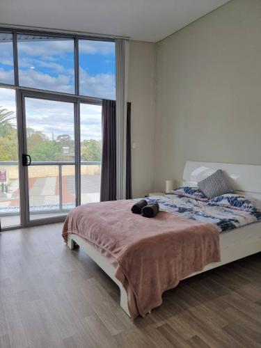 a bedroom with a large bed and a large window at Waverley apartment D-one bedroom wifi available in Perth