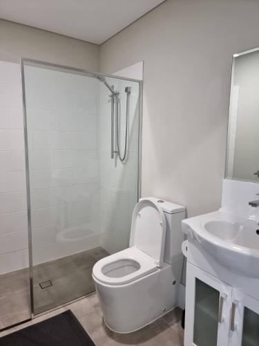 a white bathroom with a toilet and a sink at Waverley apartment D-one bedroom wifi available in Perth