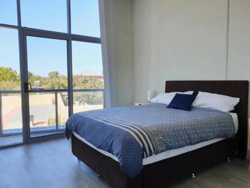 a bedroom with a bed with a large window at Waverley apartment E-one bedroom wifi available in Perth