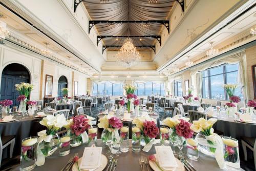 a ballroom with tables and chairs with flowers on them at Hotel Monterey Grasmere Osaka in Osaka