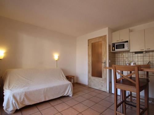 - une chambre avec un lit, une table et un four micro-ondes dans l'établissement Studio 4 pers. à Briançon – Pied de pistes, proche commerces, balcon, parking privé - FR-1-330C-53, à Briançon