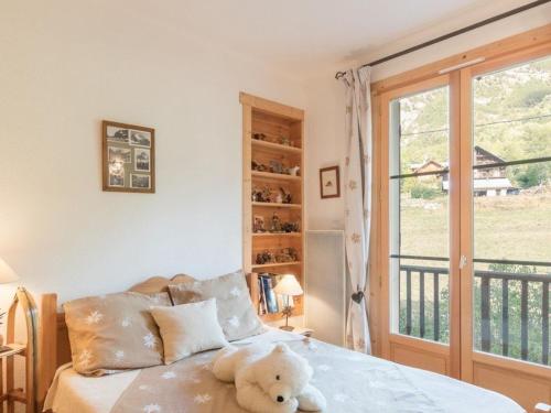 a teddy bear sitting on a bed in a bedroom at Appartement Pelvoux, 3 pièces, 6 personnes - FR-1-330G-12 in Pelvoux