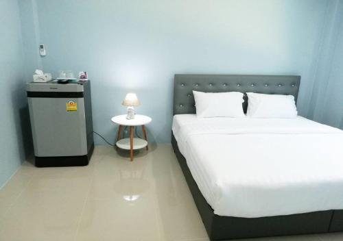 a bedroom with a bed and a small night stand at หมอกยามเช้า กะปง รีสอร์ท in Ban Mo
