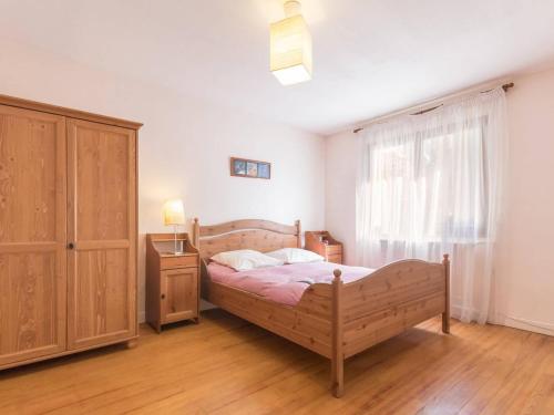 une chambre avec un lit en bois et une fenêtre dans l'établissement Spacieux Appartement 4 Pièces avec Parking à Briançon - 8 Personnes - FR-1-330C-55, à Briançon