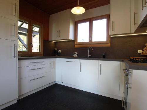 a kitchen with white cabinets and a sink at Chalet Puy Saint Vincent 1400, 5 pièces, 8 personnes - FR-1-330G-60 in Les Prés