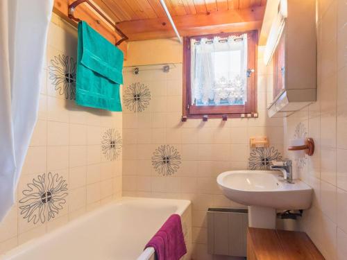 Un baño con bañera blanca y lavabo. en Charmant T2 mezzanine 5 pers, balcon sud, proche centre et pistes, parking privé - Le Monêtier les Bains - FR-1-330F-158, en Le Monêtier-les-Bains