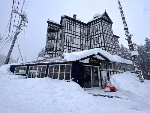 a building with a pile of snow in front of it at Hakuba Sun Valley Hotel in Hakuba