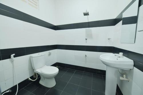 a bathroom with a toilet and a sink at Venus Resorts in Danwilana