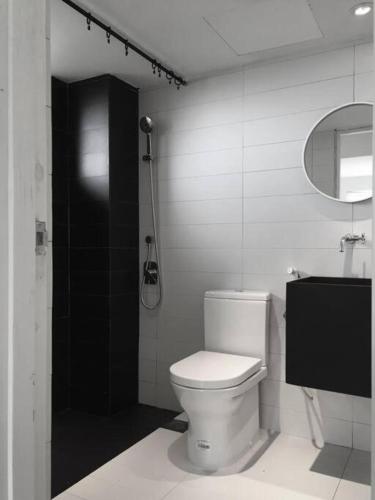 a white bathroom with a toilet and a mirror at 80 Colonie Fraser's Hill 16 Pax in Bukit Fraser