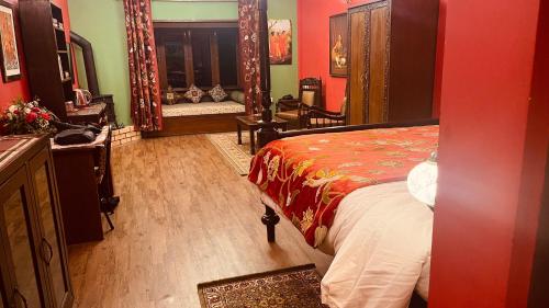 a bedroom with a bed with a red wall at Habba Kadal Kashmiri Heritage Hotel & Hub in Coonoor
