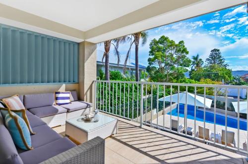 a balcony with purple furniture and a view of the ocean at The Masthead Iluka Apartment Luxury and Style in Palm Beach