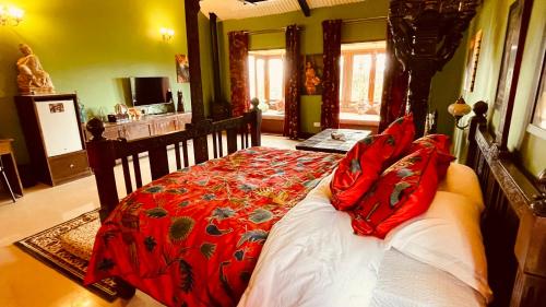 a bedroom with a bed with red pillows on it at Habba Kadal Kashmiri Heritage Hotel & Hub in Coonoor