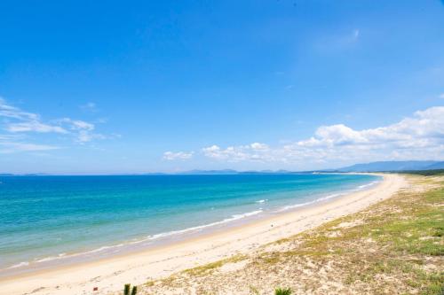 a view of a beach with the ocean at Kyukamura Shikanoshima in Fukuoka