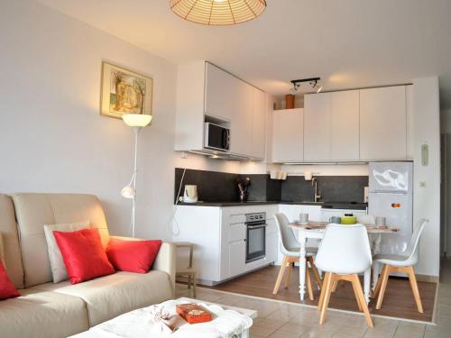 un salon et une cuisine avec un canapé et une table dans l'établissement Le Lavandou : T2 avec 4 couchages, terrasse, parking en option, animaux admis - FR-1-251-212, au Lavandou