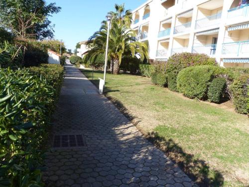 un trottoir pavé devant un bâtiment dans l'établissement Mazet charmant au Lavandou avec piscine, proche plage et commodités - FR-1-308-85, au Lavandou