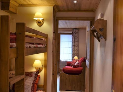 Cette chambre comprend des lits superposés et un canapé rouge. dans l'établissement Charmant Studio 4 pers à Méribel, proche centre et commerces, balcon ouest, Label Méribel - FR-1-180-372, à Les Allues
