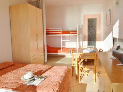 1 dormitorio con cama, escritorio y litera en Appartement Le Lavandou, 1 pièce, 4 personnes - FR-1-251-251, en Le Lavandou