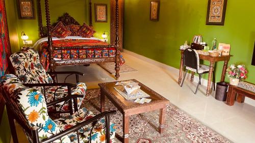 a room with a bed and a couch and a table at Habba Kadal Kashmiri Heritage Hotel & Hub in Coonoor