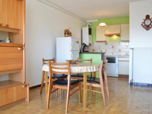 une cuisine avec une table, des chaises et un réfrigérateur dans l'établissement App. 2 pièces, climatisé, parking, 200m de la plage - FR-1-225C-549, à Banyuls-sur-Mer