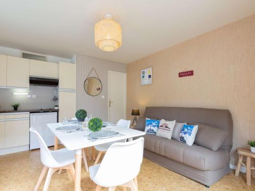 un salon avec un canapé, une table et des chaises dans l'établissement Charmant Appart, Proche Thermes et Téléphérique, Parking Gratuit, Animaux Acceptés - FR-1-296-445, à Saint-Lary-Soulan