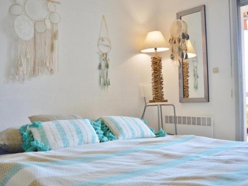 a bedroom with a bed and a lamp and a mirror at Appartement Le Lavandou, 1 pièce, 4 personnes - FR-1-251-232 in Le Lavandou