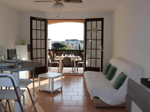 d'un salon avec un canapé et une table ainsi que d'un balcon. dans l'établissement Studio-cabine lumineux avec terrasse, parking, proche plage - FR-1-100-119, à Cavalaire-sur-Mer
