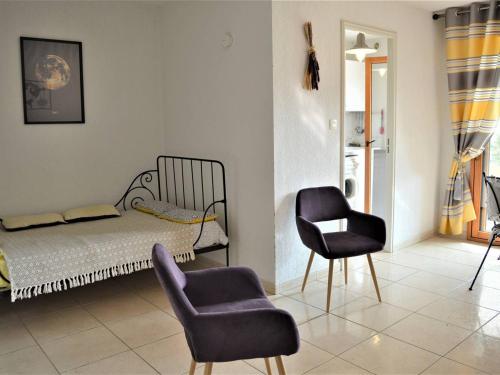 - une chambre avec un lit et deux chaises dans l'établissement Appartement Moderne 2P, Jardin, Terrasse, Proche Plage et Commerces - Cavalaire - FR-1-226B-338, à Cavalaire-sur-Mer