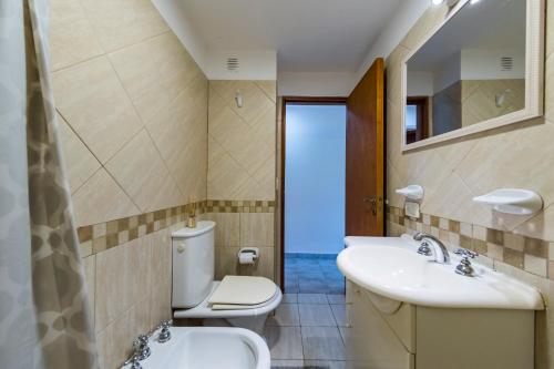 y baño con aseo, lavabo y espejo. en Viaggiato Alta Cordoba en Córdoba