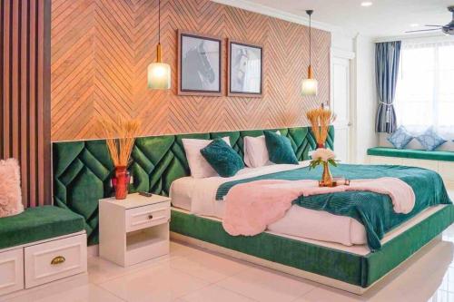 a bedroom with two beds and a green couch at Pattaya Pool Villa-Exquisite Pool Villa H in Nong Prue