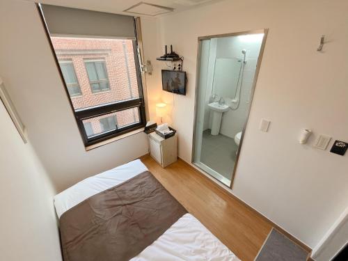 a small bathroom with a toilet and a mirror at K9 Myeongdong Hotel in Seoul