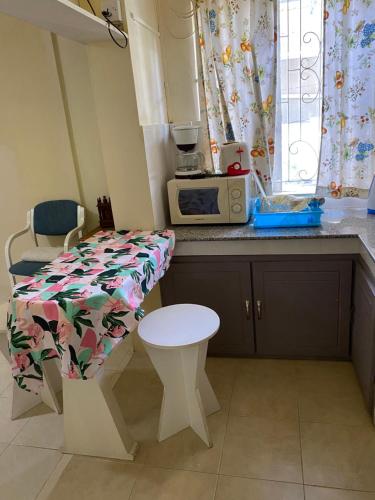 a small kitchen with a table and a microwave at Gardenia Apartments in Pereybere