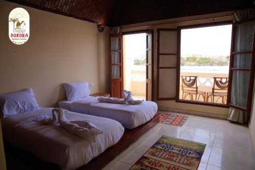 Shellal的住宿－DoroKa Nubian House，客房设有两张床和一个美景窗户。