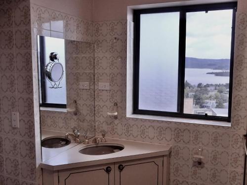 a bathroom with a sink and a mirror and a window at Top Deck by Kristall Apartments in Jindabyne