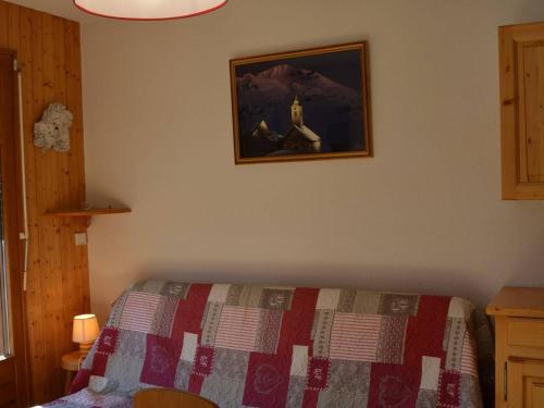 ein Schlafzimmer mit einem Bett und einem Bild an der Wand in der Unterkunft Appartement Le Grand-Bornand, 2 pièces, 6 personnes - FR-1-241-188 in Le Grand-Bornand