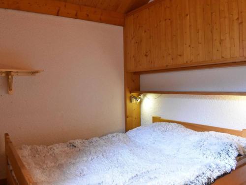 une chambre avec un lit blanc avec une tête de lit en bois dans l'établissement Appartement 3 pièces, 6 pers, proche pistes, parking - FR-1-180-365, à Les Allues