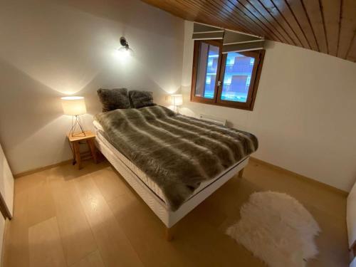 um quarto com uma cama grande e uma janela em Appartement Le Grand-Bornand, 2 pièces, 6 personnes - FR-1-241-186 em Le Grand-Bornand